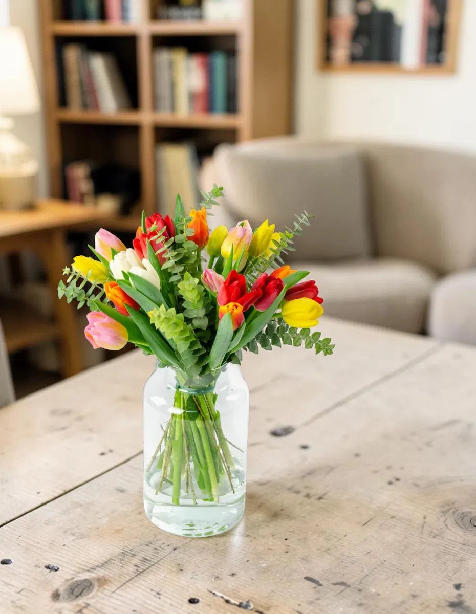 Ramo de tulipanes mixtos en jarrón sobre mesa de salón - Floristería Peregrina Pontevedra